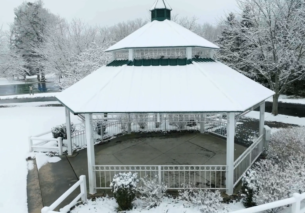 gazebo in a park covered with snow in the winter