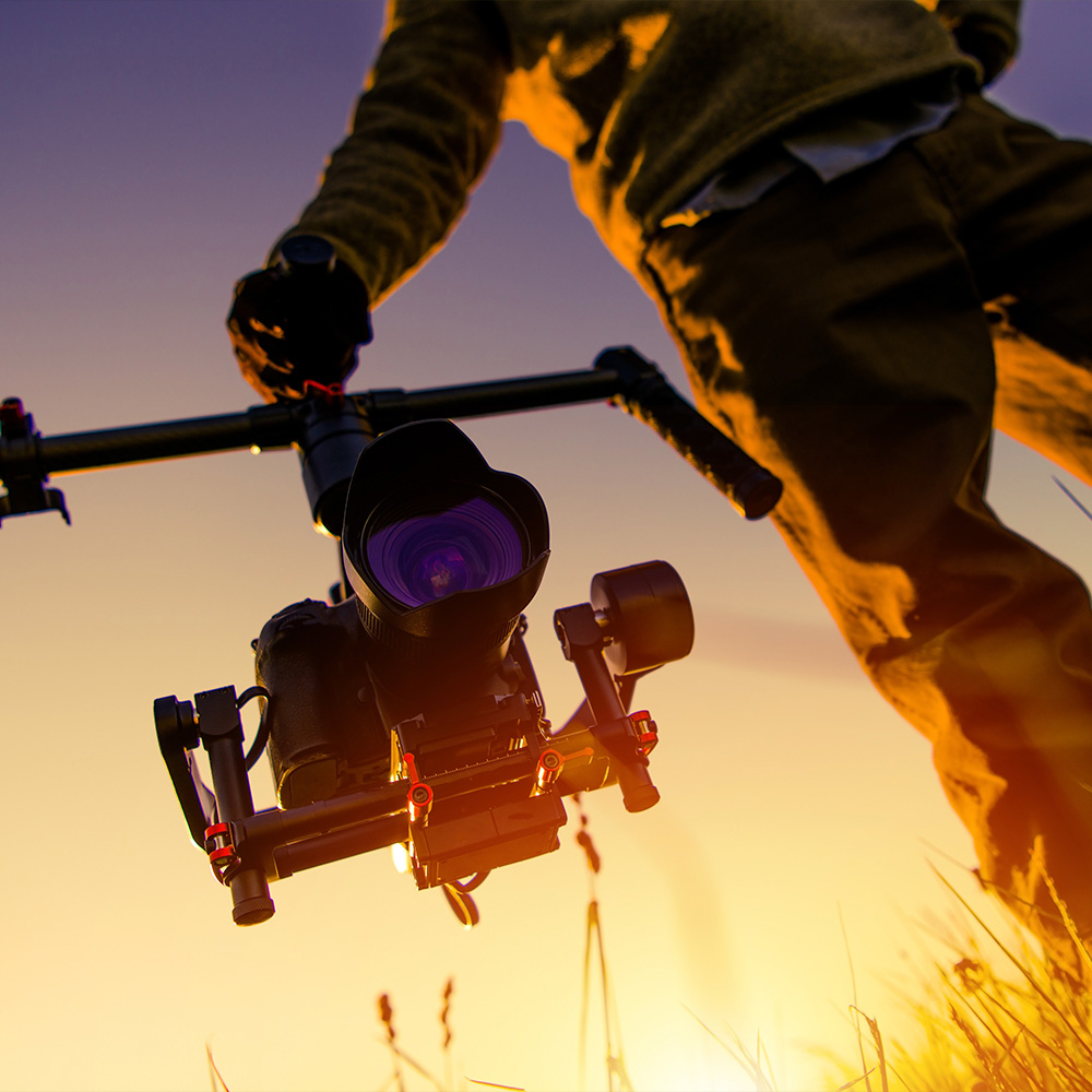 a person holding a drone in the sunset